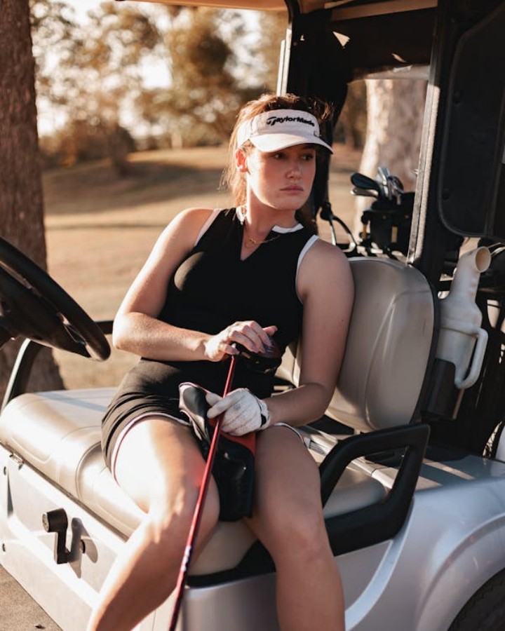 A golfer in a golf cart with accessories